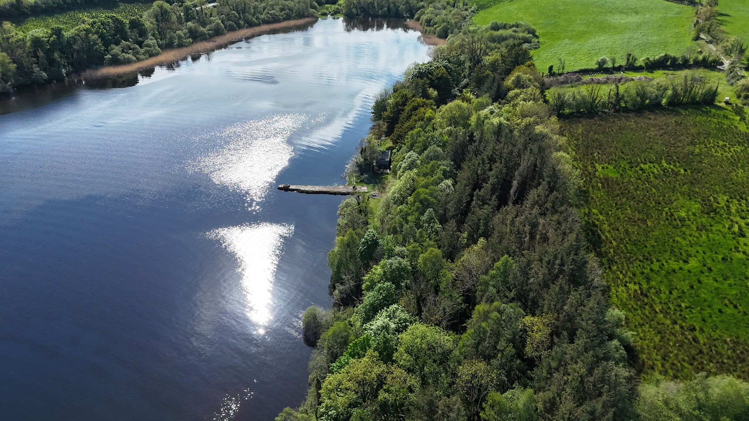 Oblique aerial view along the shoreline, with the jetty visible