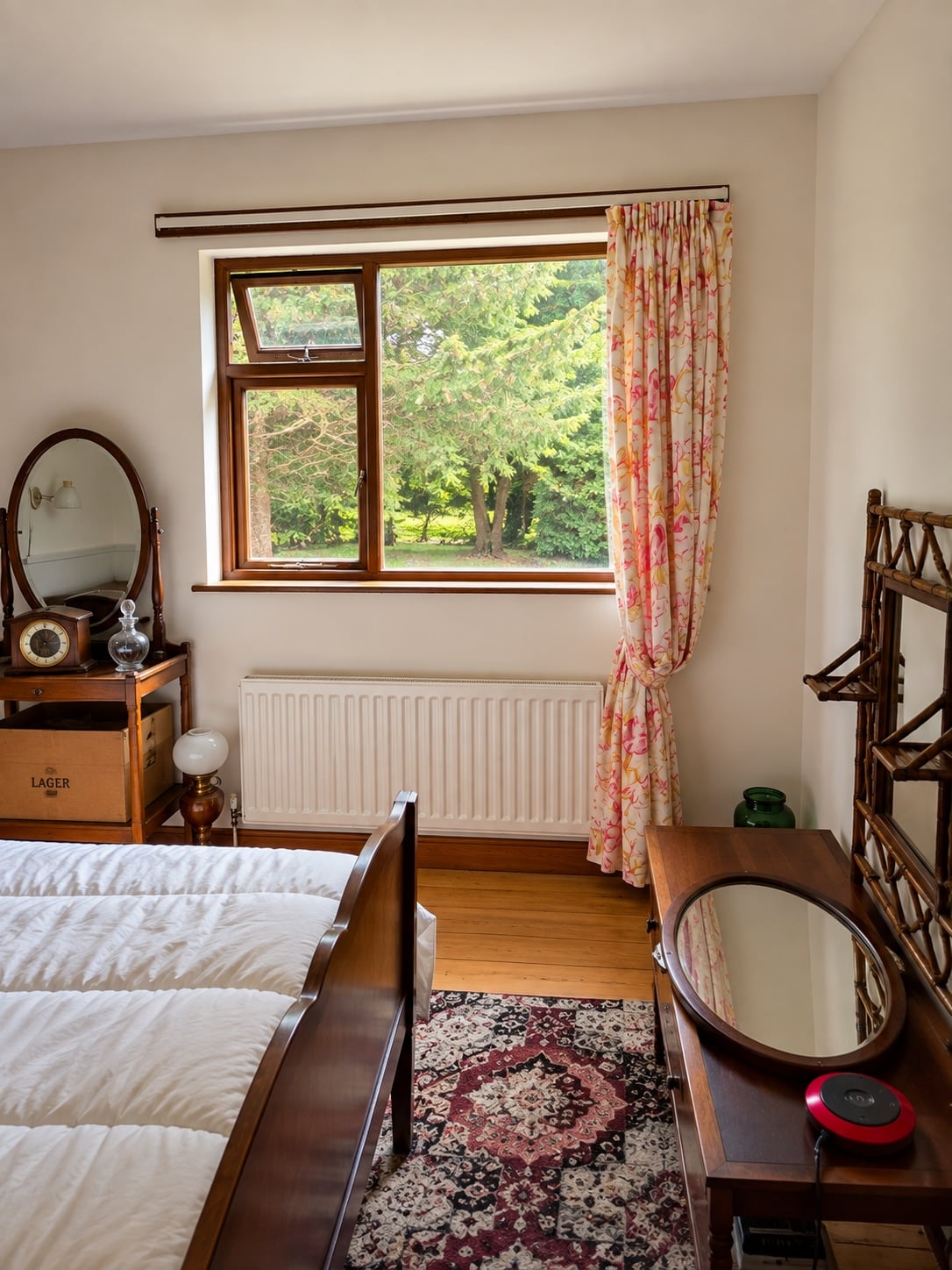 Bedroom with wooden flooring and a window overlooking the grounds