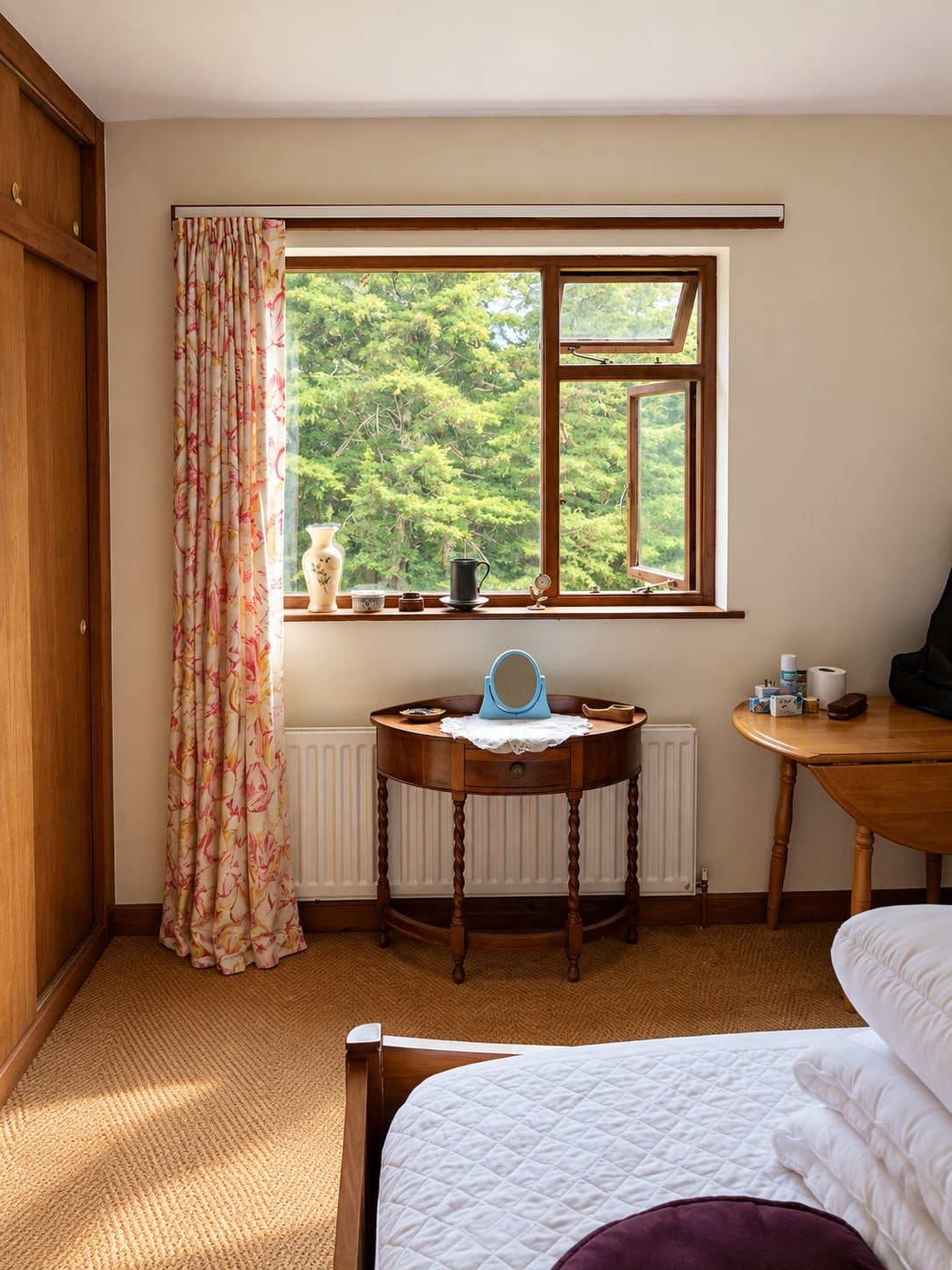 Bedroom with fitted wardrobes and a dressing table beside the window